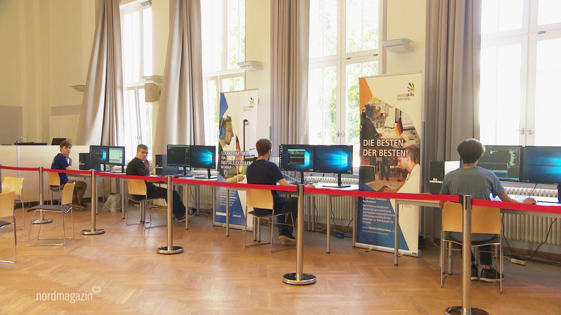 Junge Softwareentwickler sitzen vor Monitoren.  