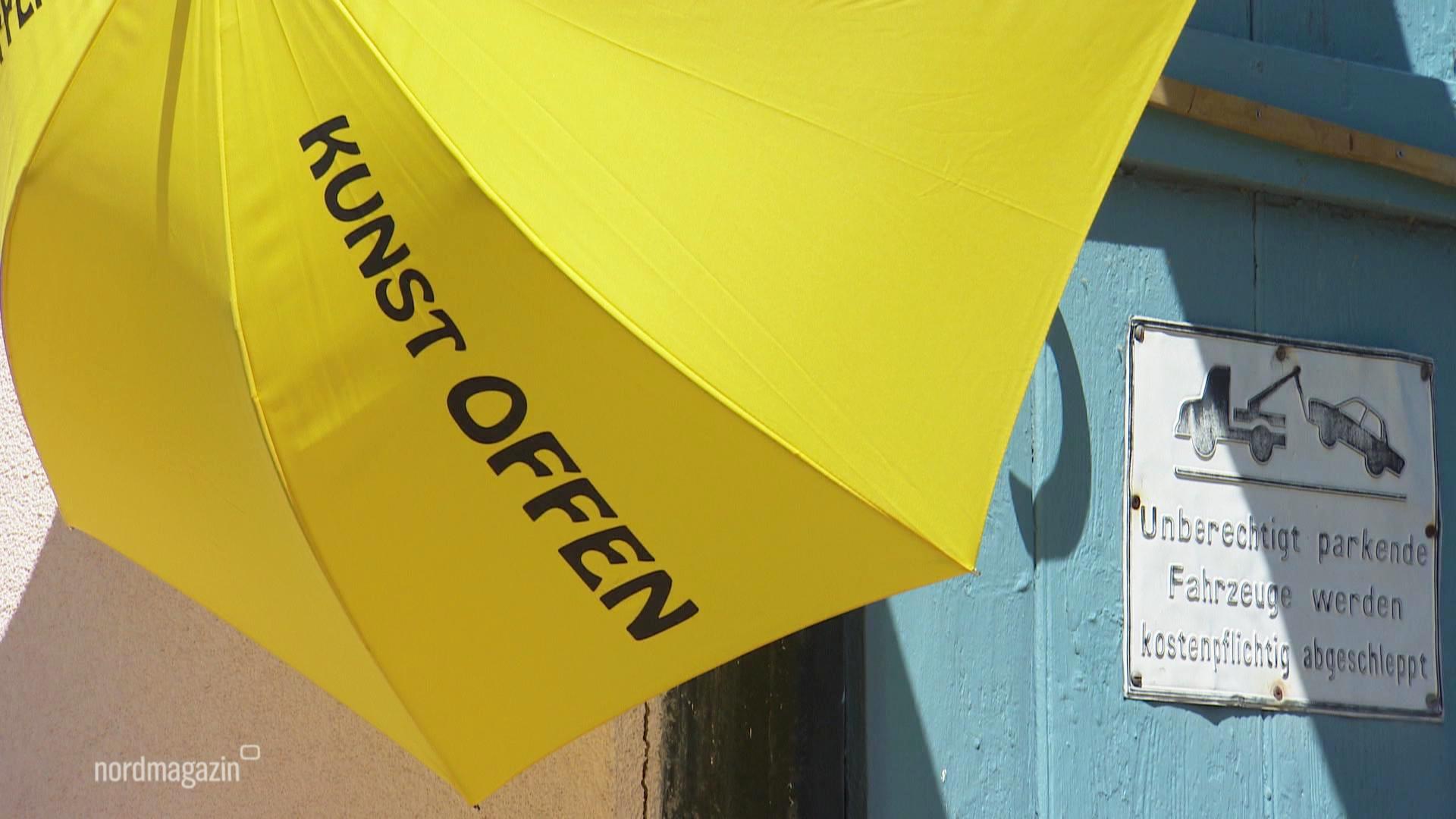 Ein Regenschirm mit der Aufschrift "Kunst offen". © Screenshot 