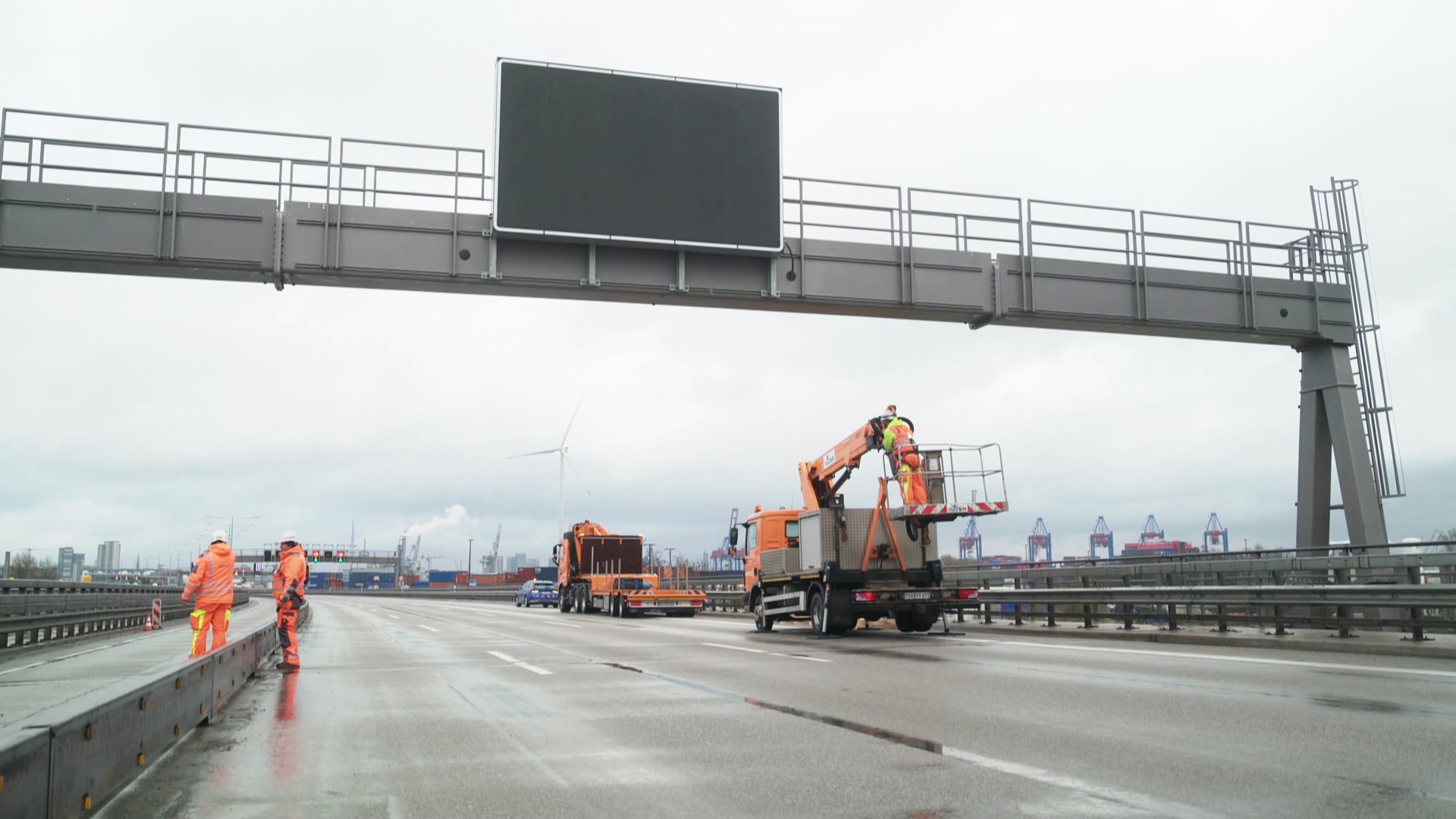 Arbeiter an einer Schilderbrücke über der vollgesperrten A7 in Hamburg. © Screenshot 