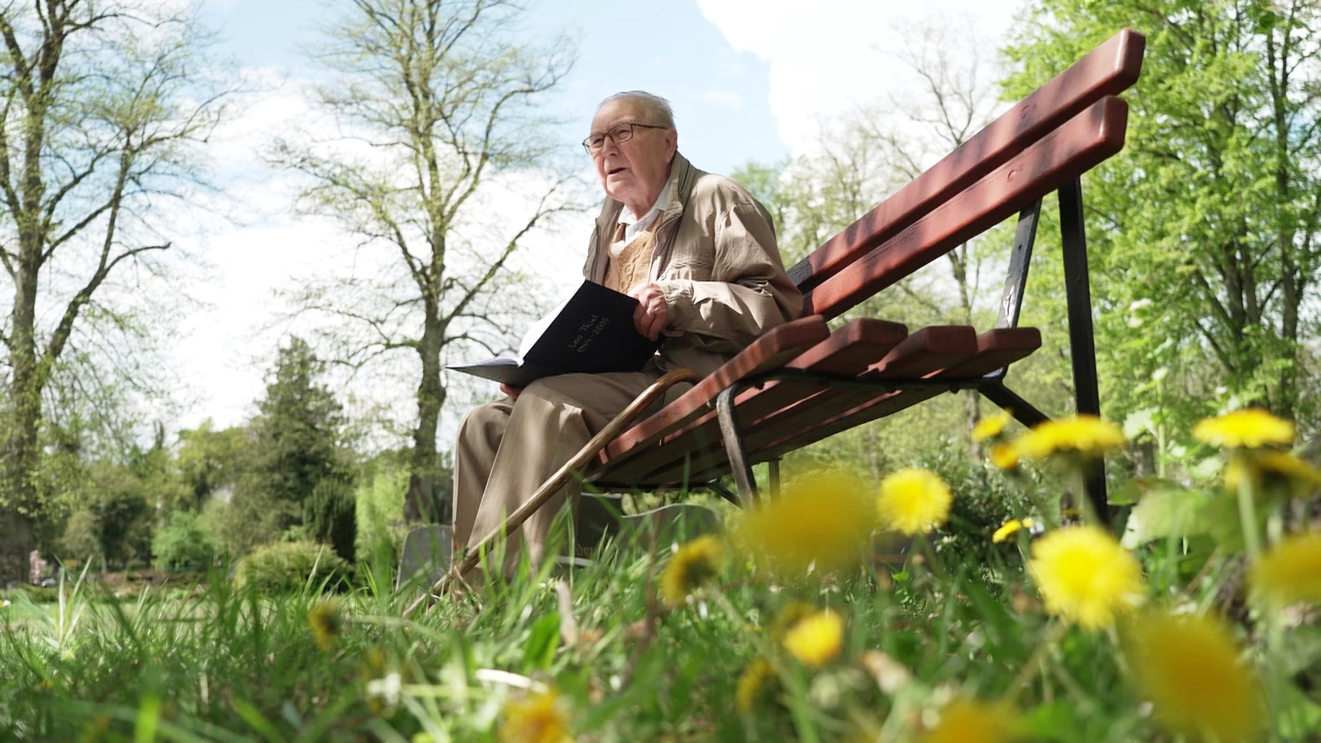 Der 95-jährige Leo Thiel sitzt auf einer Parkbank und hat ein Buch in seinen Händen. © NDR 