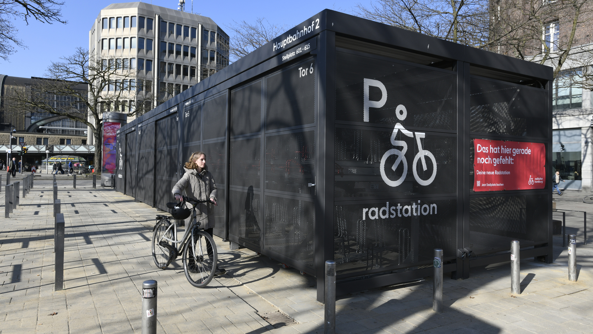 Eine Fahrradfahrerin steht vor einer neuen Radstation am Hamburger Hauptbahnhof. © Radkultur Hamburg 