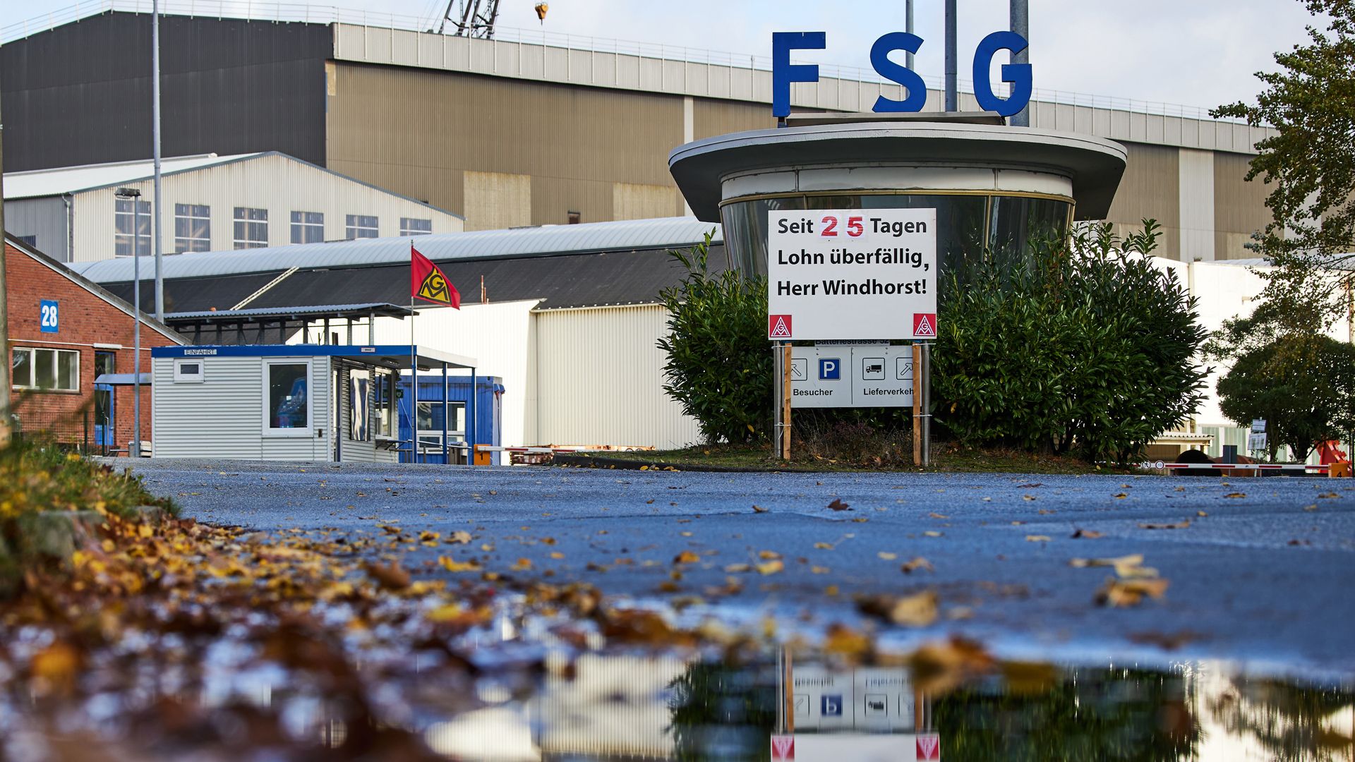 An der Zufahrt zum Werftgelände der Flensburger Schiffbau-Gesellschaft steht ein Schild mit der Aufschrift "Seit 25 Tagen Lohn überfällig, Herr Windhorst!" © picture alliance / Jörg Carstensen 