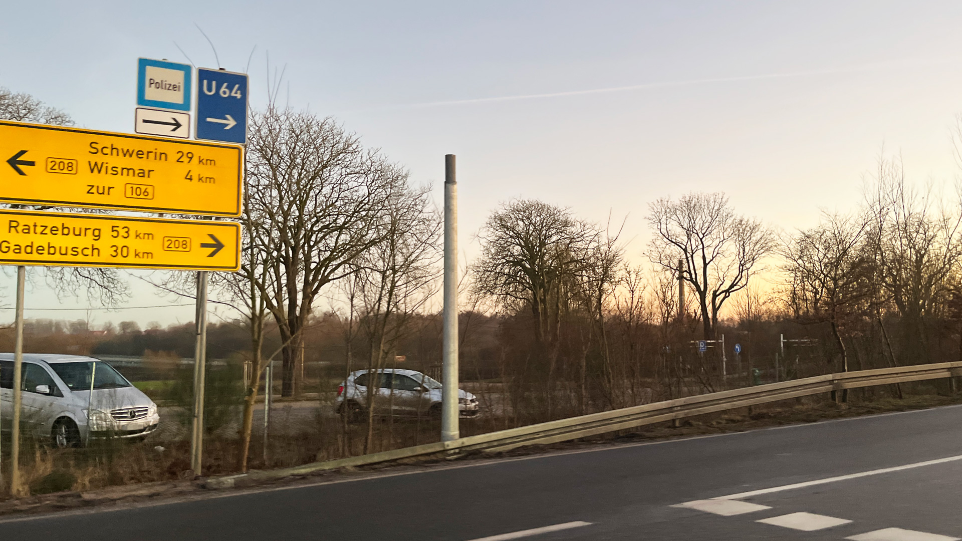 Ein etwa 5 Meter hoher Mast, auf dem oben die Ampel fehlt, steht an einer Straße. Daneben zeigen Wegweiser nach Schwerin, Wismar, Gadebusch und Ratzeburg. © NDR Foto: Christoph Woest