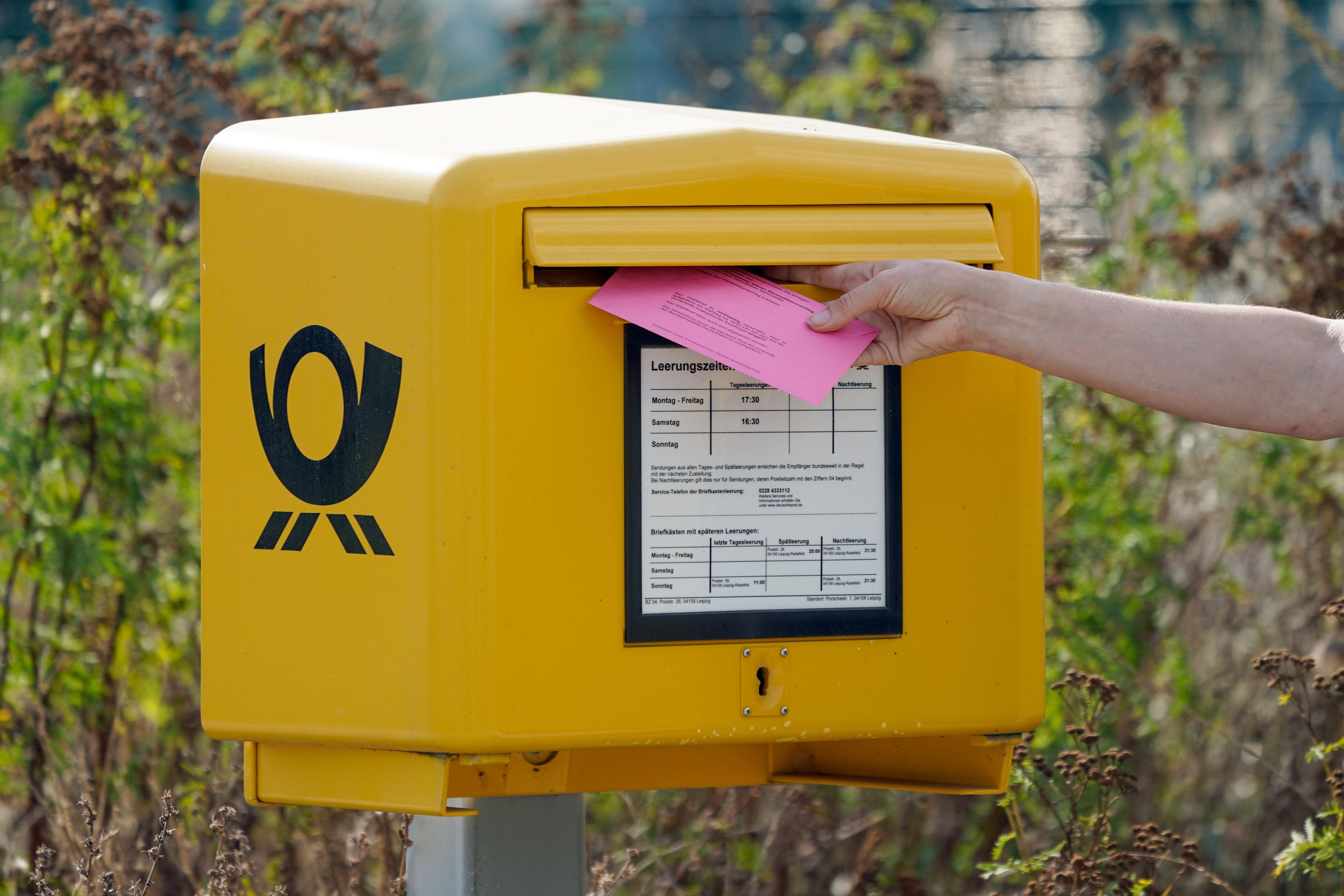 Eine Person wirft ihren Umschlag zur Briefwahl in einen Briefkasten. © dpa Foto: Peter Endig