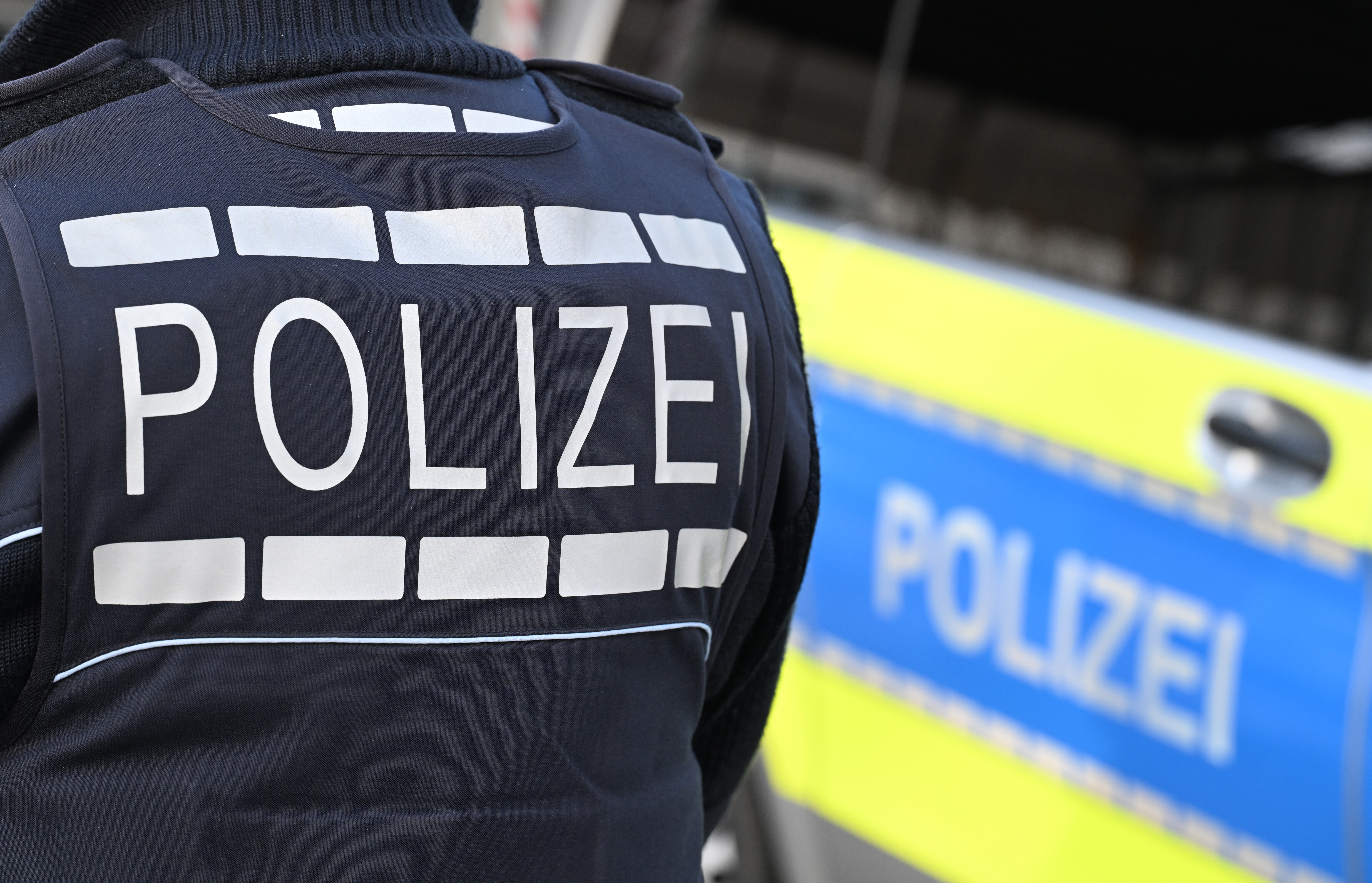 Der Schriftzug «Polizei» ist auf einem Einsatzfahrzeug und auf der Dienstkleidung der Polizei aufgebracht. © Bernd Weißbrod 