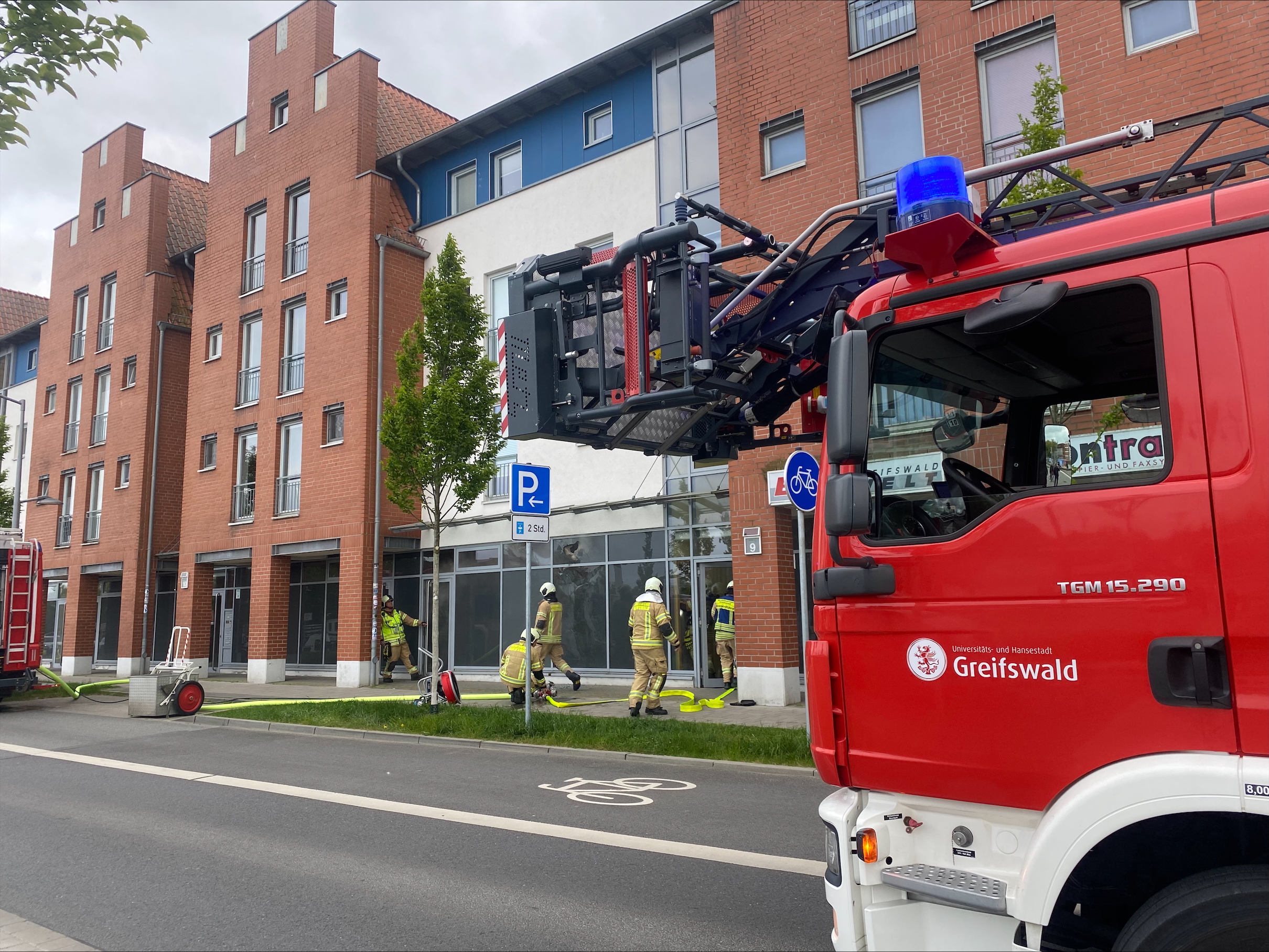 Blick vorbei an einem Feuerwerhrauto auf fünf Feuerwehrleute im Einsatz. © NDR Foto: Hannah Deutwiz