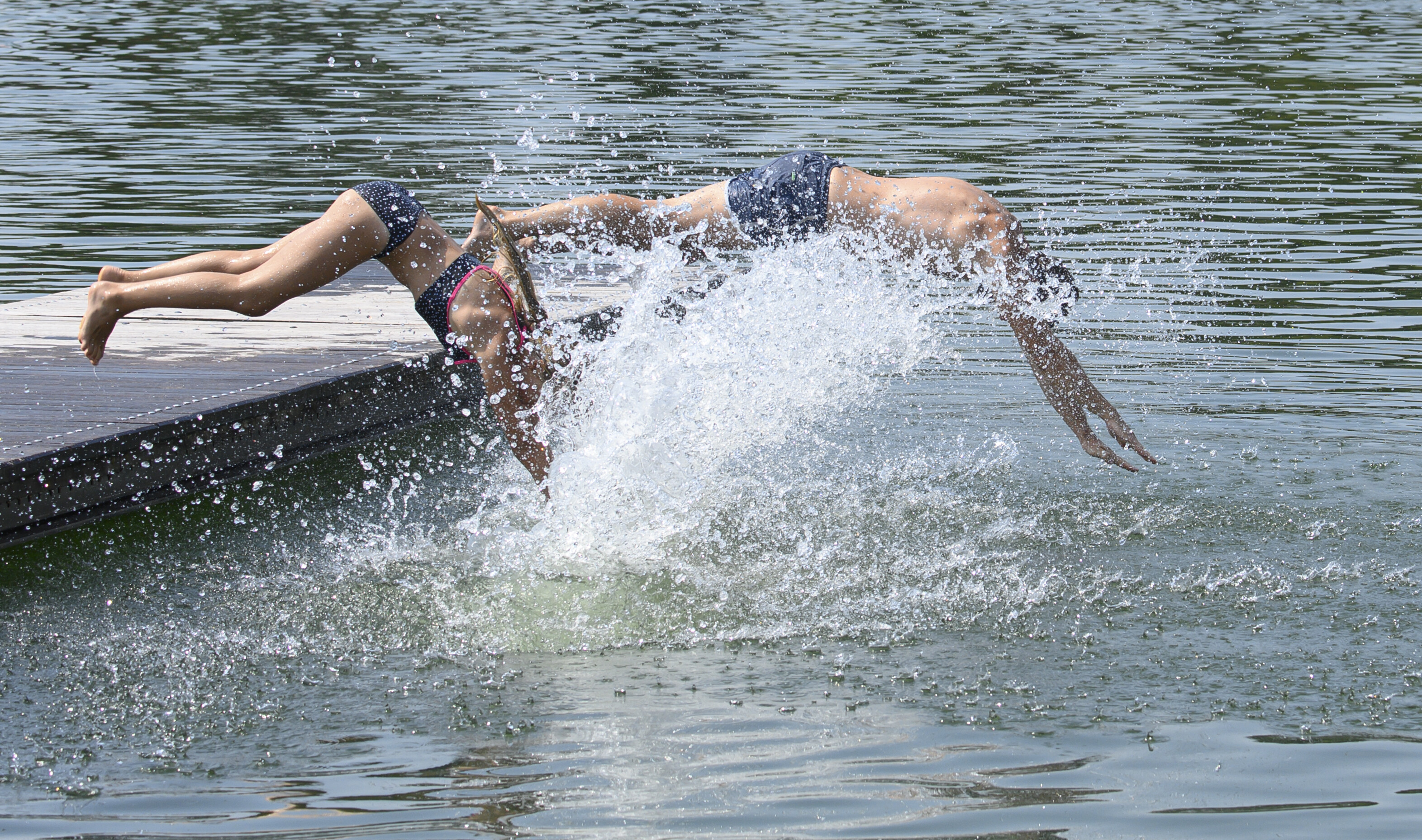 Badegäste springen von einem Steg ins Wasser. © picture alliance/dpa Foto: Robert Michael