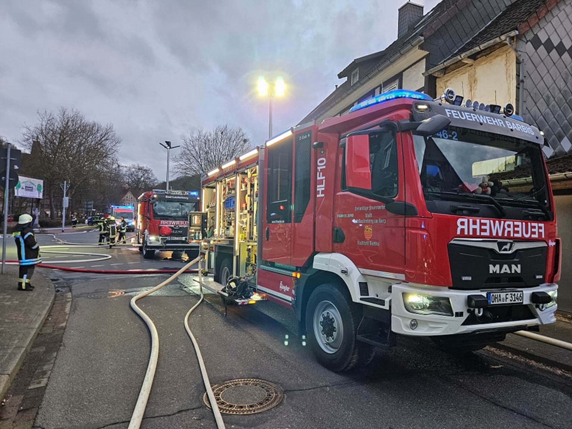 Zwei Feuerwehrautos, an denen Schläuche befestigt sind, stehen während eines Einsatzes an einer Straßenabbiegung. © Freiwillige Feuerwehr Barbis 