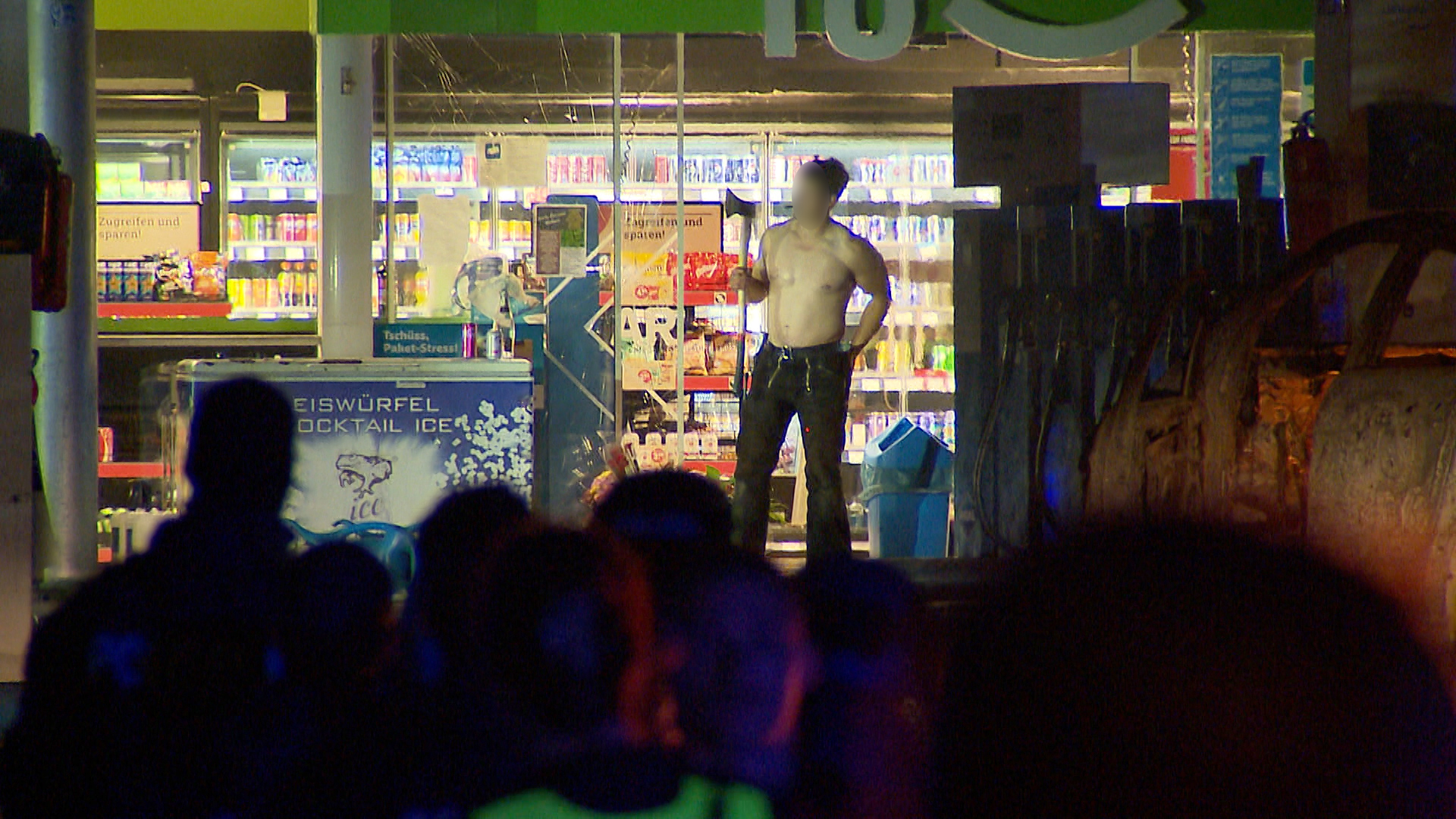 Ein Mann mit einer Axt steht vor einer Tankstelle in Hannover Anderten. © NonstopNews 