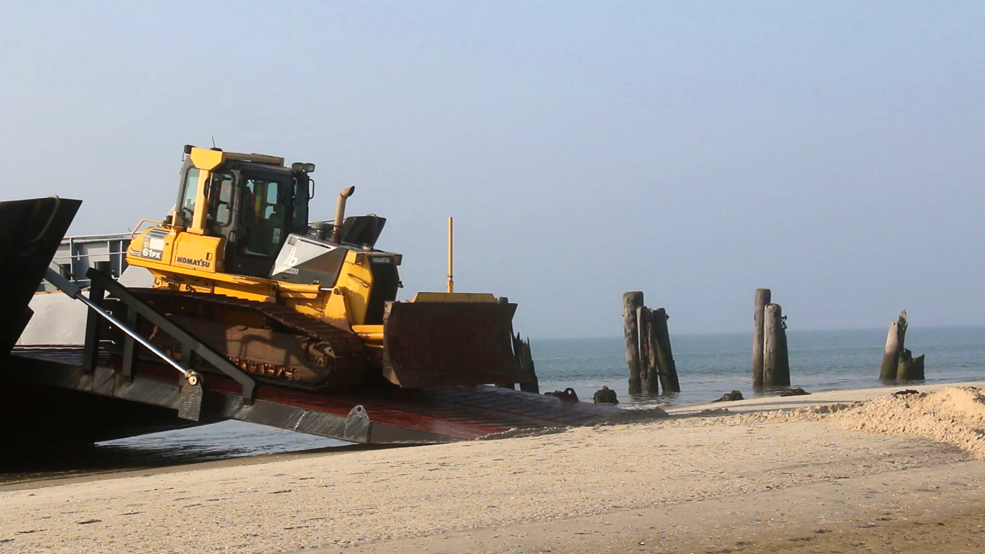 Ein Radlader fährt von einem Schiff an einen Strand auf der ostfriesischen Insel Wangerooge. © NonstopNews 