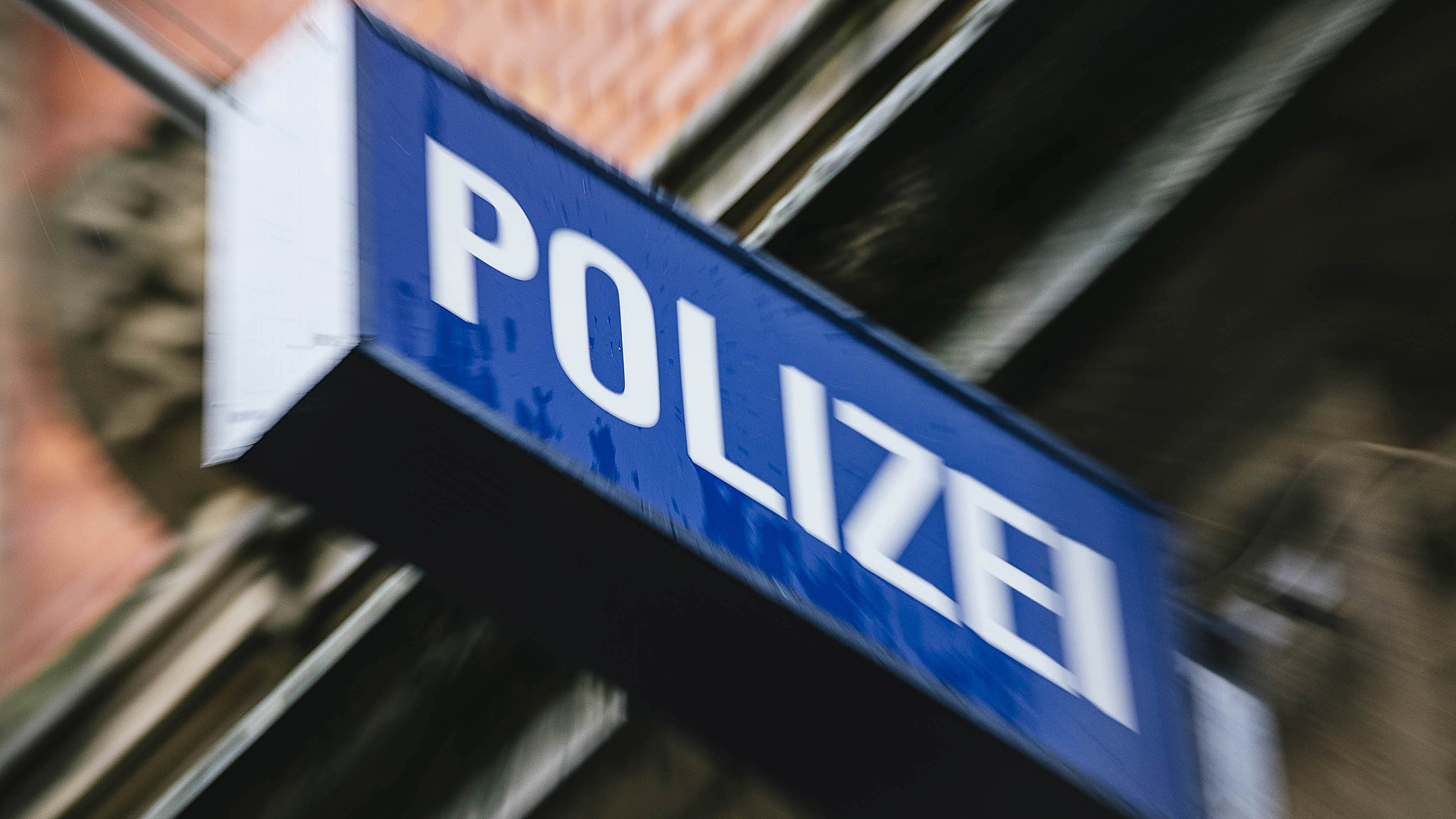 An einer Hausfassade hängt ein Leuchtschild mit der Aufschrift Polizei. © NDR Foto: Julius Matuschik