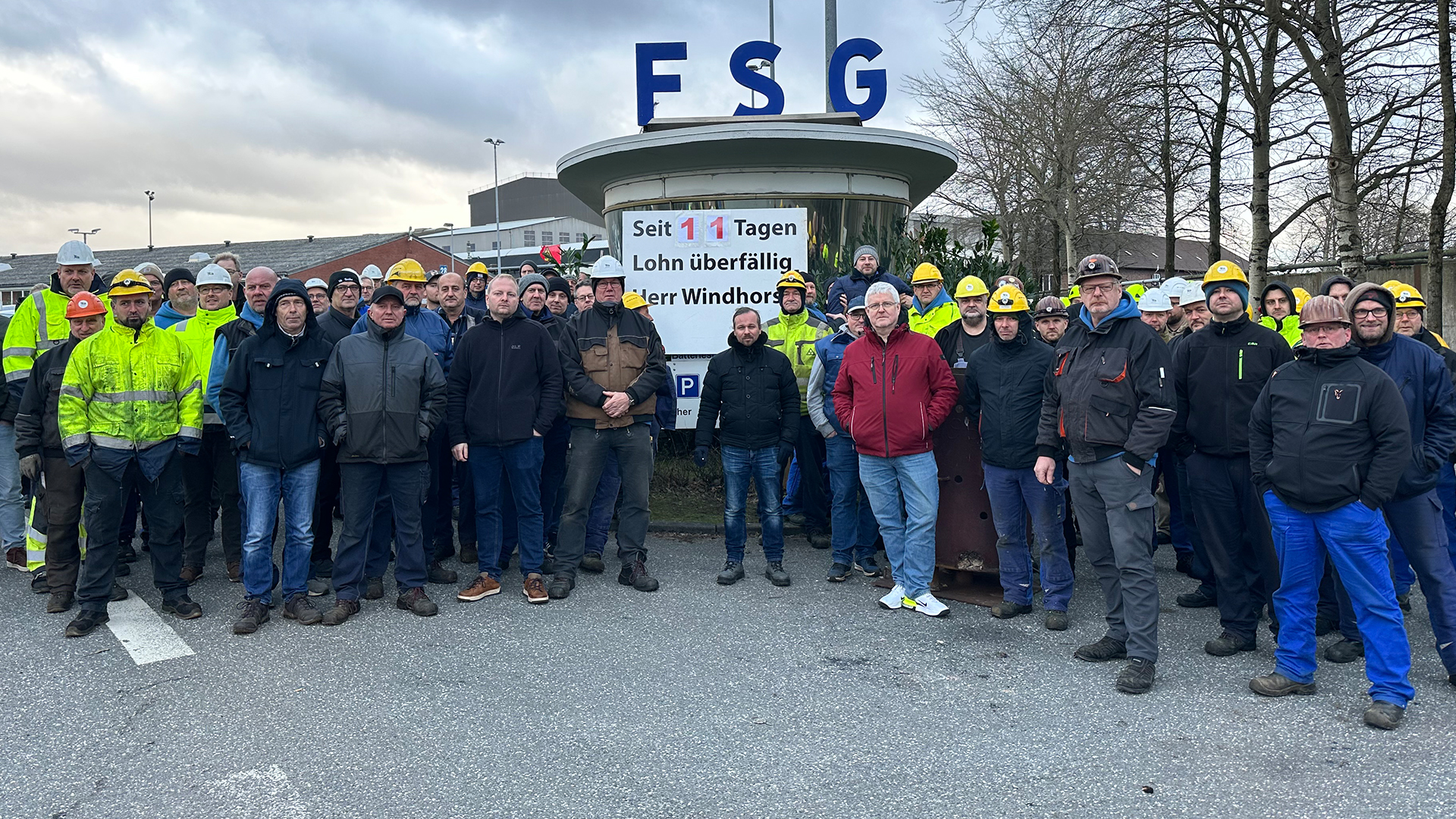 Mitarbeiter der FSG stehen vor dem Eingang der Firma. © NDR Foto: Ben Armstrong