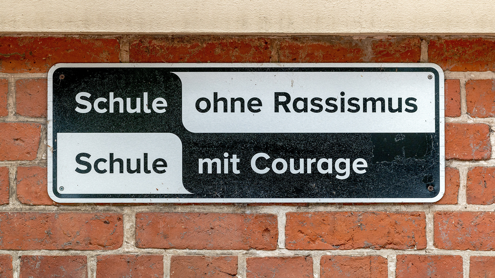 Ein Schild auf dem steht "Schule ohne Rassismus - Schule mit Courage". © picture alliance / SULUPRESS.DE Foto: Torsten Sukrow