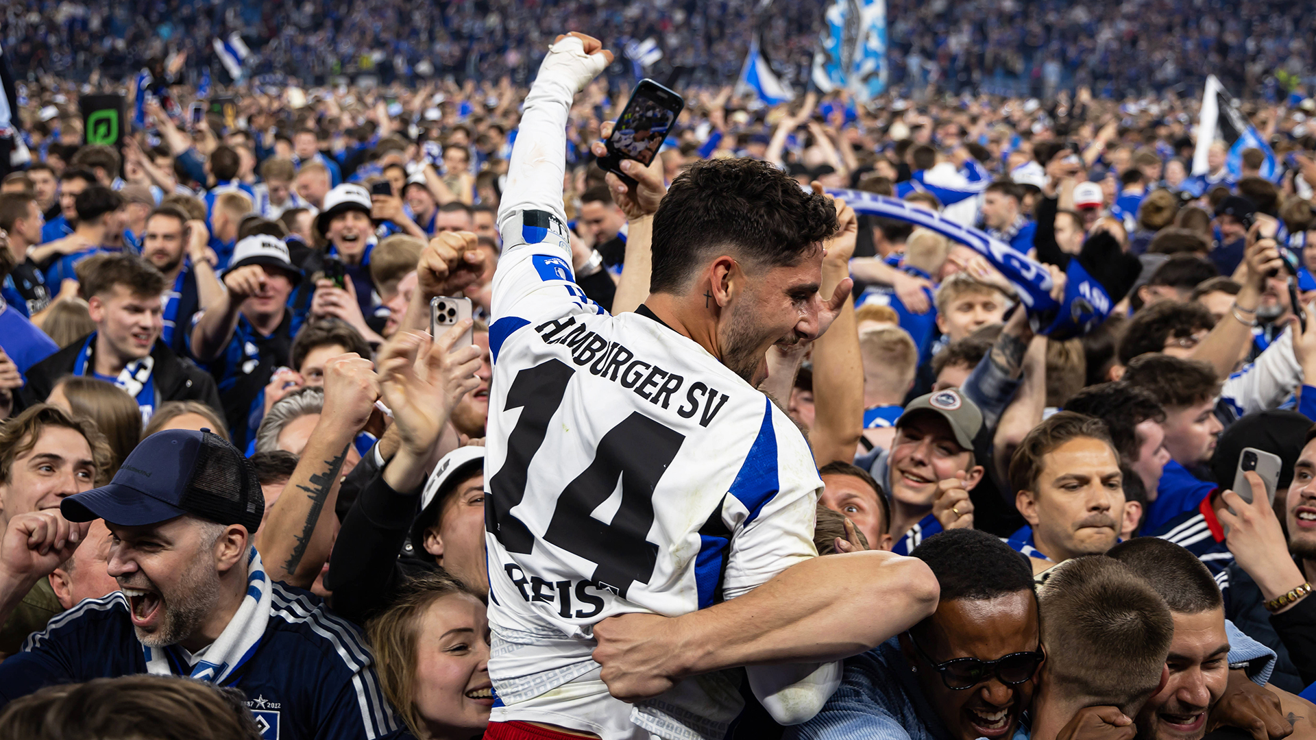 HSV-Spieler Ludovit Reis feiert inmitten von Fans den Aufstieg. © IMAGO / Beautiful Sports 